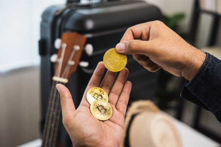 Close up traveler hand man showing cryptocurrency digital coin for travel payment. Trolley bag on...