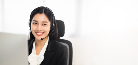 Call centre female operator. Smiling asian business woman receptionist wearing headphone video...