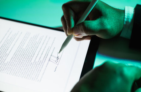 Close up businessman hand electronic Signature on Tablet by Stylus. Write business agreement of contract. Man signing contract on tablet. Business and technology concept.の写真素材