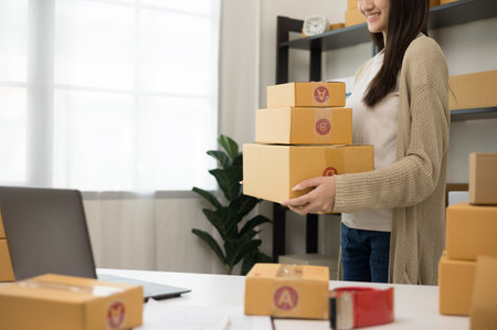 Entrepreneur standing pose holding lot of parcel paper cardboard. Female small Business owner with...