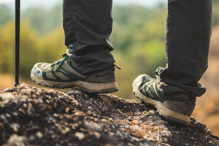 Close up mountaineering boots walking on rocky mountains at  outdoor. Tourist walks on adventure trip in natural at holidays. Travel lifestyle conceptの写真素材