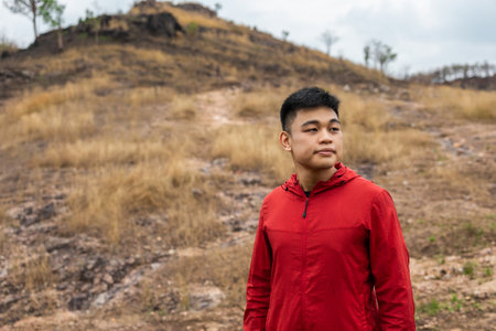 Young handsome asian Trail runner man standing on top of the mountain. Athlete jog outdoor for healthy. Confident and powerful marathon man running workout and cardio. Sport and Lifestyle concept.の写真素材