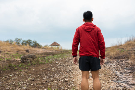 Rear view Trail runner man running on rocky mountain. Athlete jog exercising outdoor for healthy....