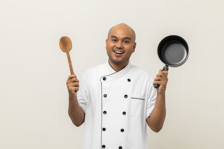 Young handsome asian man chef in uniform holding ladle and pot utensils cooking in the kitchen various gesture action on isolated background. Indian man Occupation chef restaurant and hotel.の写真素材