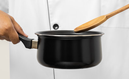 Close up Young asian man chef in uniform holding ladle and pot utensils cooking in the kitchen various gesture action on isolated background. Indian man Occupation chef restaurant and hotel.の写真素材
