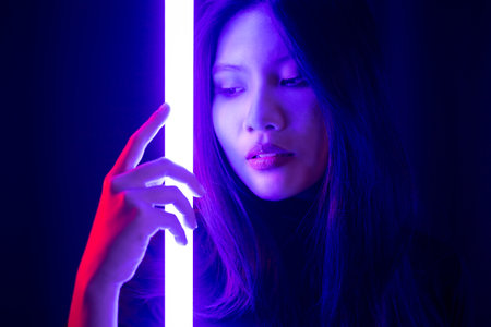Stylish sexy woman in trendy. Beautiful young asian woman standing pose with neon light. Asia Pretty asian female in the dark room. Fashion shot.の写真素材