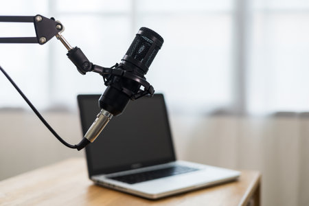 Condenser microphone in recording home studio. Content creator working with laptop host streaming radio podcast interview conversation at home broadcast studio recording voice over radioの写真素材