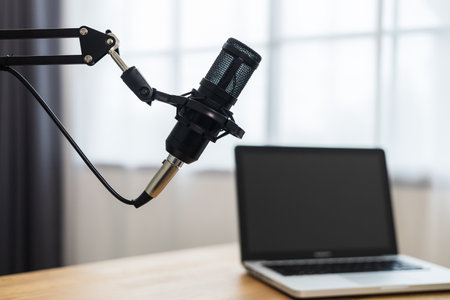 Condenser microphone in recording home studio. Content creator working with laptop host streaming radio podcast interview conversation at home broadcast studio recording voice over radioの写真素材