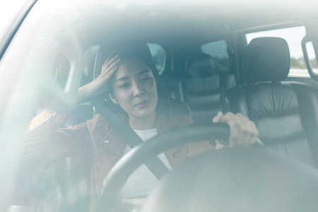 Young asian woman has broken down car on the road she feeling serious and stressed.Look for someone help. Driving during rush hour But the traffic is very congested. Shocked faceの写真素材