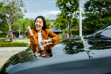 Young beautiful asian woman getting the new car. She hugged her car and was very happy. Buy or rent car concept.の写真素材