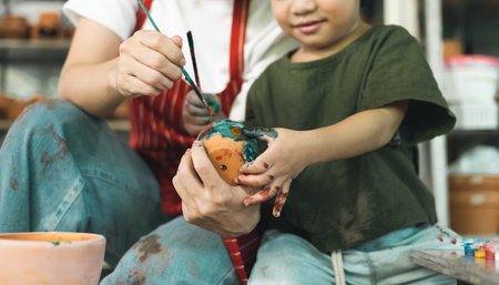 Happy family moment Mother teaching son how to painting mug cup ceramic workshop. Child creative activities and art. Kid playing  pottery workshop. Developing children's learning skills.の写真素材