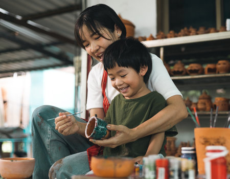 Happy family moment Mother teaching son how to painting mug cup ceramic workshop. Child creative activities and art. Kid playing  pottery workshop. Developing children's learning skills.の写真素材