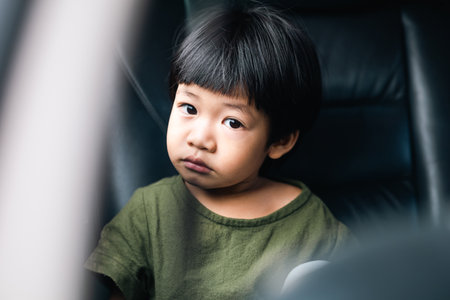 Kid in car. Asian Child sitting on the back seat in car.
