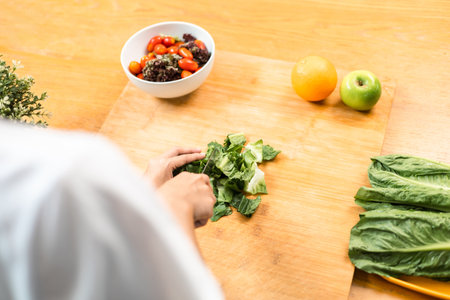 Female slicing and cooking green apple on cutting board for vegetable salad in weight loss diet....