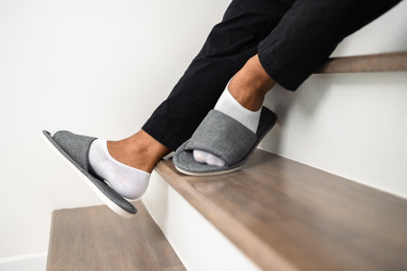 A man walked up and down the stairs and stumbled upon the steps until he fell injuring his ankle....