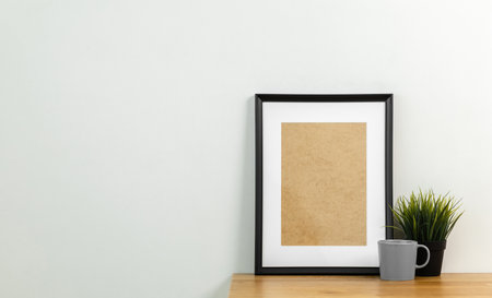 Style picture frame still life put on the wooden table. Blank space empty picture frame with mockup. Shot in studio with natural light. Template background interior design and decoration.の写真素材