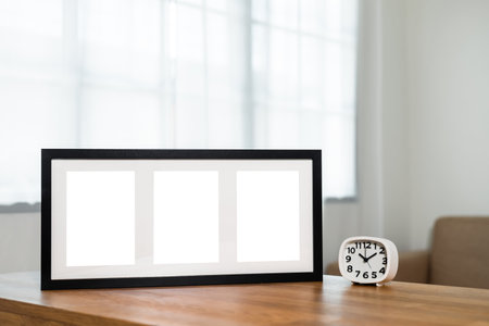 Style picture frame still life put on the wooden table in living room. Blank space empty picture frame with mockup. Natural light Template background interior design and decorationの写真素材