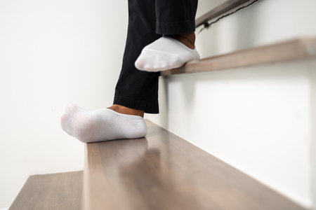 A man walked up and down the stairs and stumbled upon the steps until he fell injuring his ankle....