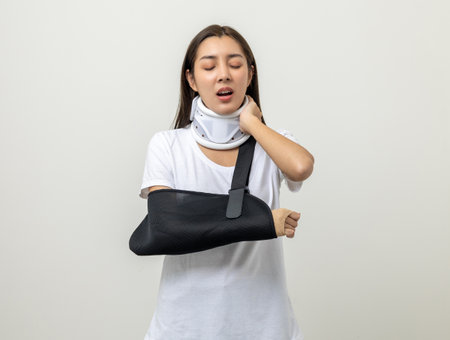 Depressed upset woman suffering from pain. Broken arm. Asian woman put on plaster bandage cast splint. Patient wearing sling support arm after accident injury. life insurance and accidentの写真素材