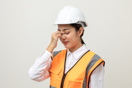 Asian engineer worker woman or architect with white safety helmet standing on isolated white...