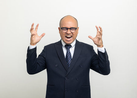 Depressed stressed. Young asian businessman on isolated white background. Angry middle aged Indian businessman in office uniform.の写真素材