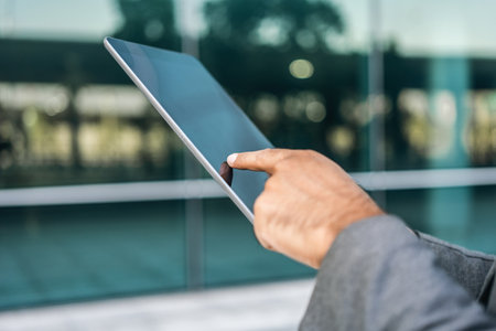 Senior manager business man in suit with tablet at the buildings downtown. Confident man using...