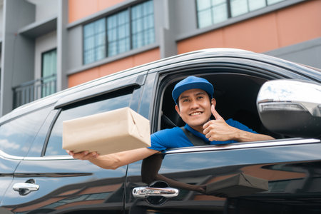 Asian delivery man with parcel in hand of blue uniform sending parcel to customer Sticking his head...