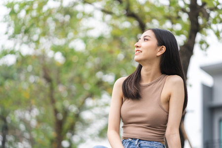 Happy feeling of Beautiful Young Woman smiling outdoor in sunlight. Pretty attractive face of female and beautiful smile. She is positive thinking and successful.の写真素材