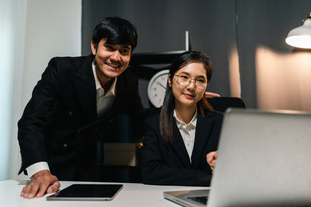 Couple two business man and woman working late at night. Discussion in office working with laptop....
