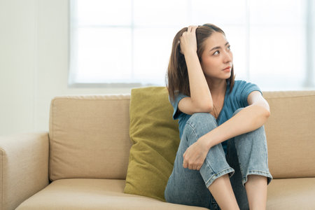 Depressed and Stressed asian woman on sofa. Crying sadness female alone in home problem in life....