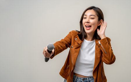 Happiness young asian woman singing song. Artist vocalist singer on isolated background. Confident woman public speaking talking with microphone in studio.の写真素材