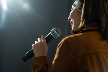 Close up woman hand holding High quality dynamic microphone and singing song or speaking talking with people on isolated white background. Woman testing microphone voice for interviewの写真素材