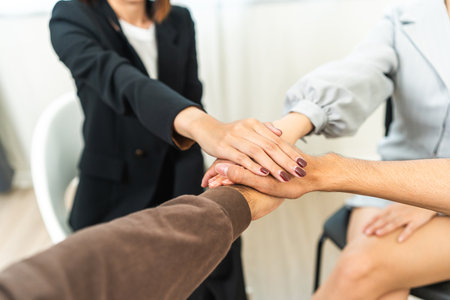 Multiethnic of young people putting their hands together in group therapy session. Support of counselor diverse people friend group help motivation making a stack of hands.の写真素材