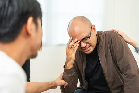 Group therapy session. Crying asian man feel pain upset depression talk about problems in life. Get psychological support of counselor diverse people friend group help motivation.の写真素材