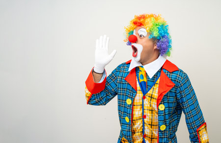 Mr Clown. Funny shocked face comedian Clown man in colorful costume wearing wig shout out loud wow with hands on mouth announcement. Happy expression amazed bozo in various pose on isolated.の写真素材