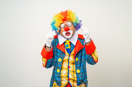 Mr Clown. Portrait of sadness face Clown man in colorful uniform standing crying feeling sad emotional. Expression male bozo in various pose on isolated background.の写真素材