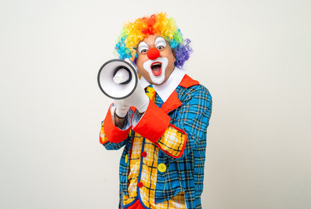 Mr Clown. Funny shocked face comedian Clown man in colorful costume wearing wig shout out loud wow with megaphone mouth announcement. Happy expression amazed bozo in various pose on isolated.の写真素材