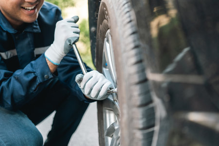 Professional car mechanic maintenance vehicle. The mechanic opens the front of the car. Checking the broken engine. Check the damage as listed. Repair car outside service.の写真素材