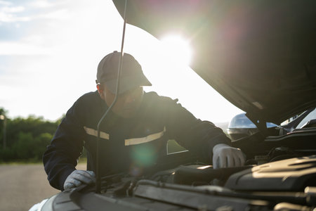 Professional car mechanic maintenance vehicle. The mechanic opens the front of the car. Checking the...