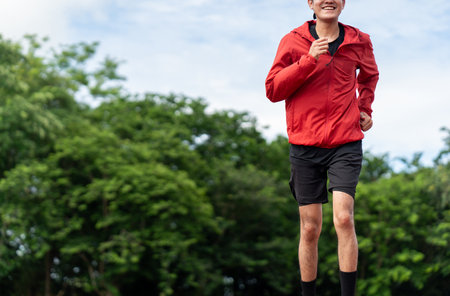 Attractive Young indian man wearing sportswear running on track at sport stadium. Asian Fit man...