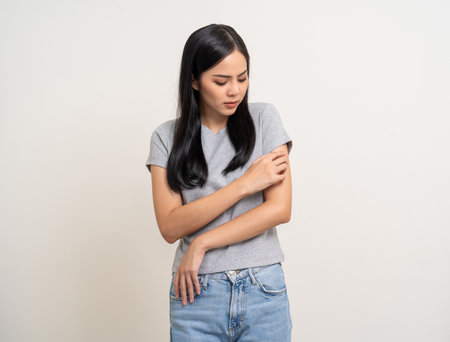 Asian women have skin problems She felt irritation on her skin. Skin infection itching red rash scratching with hands. Unwell unhealthy female standing on isolated backgroundの写真素材