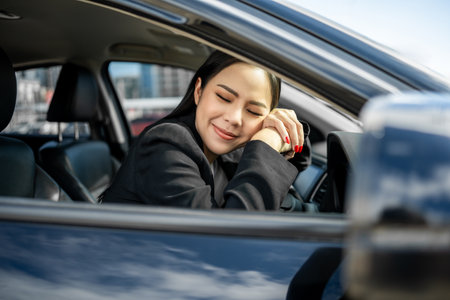 Young beautiful asian business women getting new car. Happy smiling female driving vehicle on the road hugging steering wheel touching detail car interior. Business woman buying driving new carの写真素材