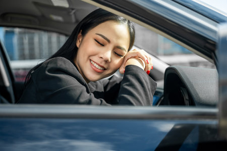 Young beautiful asian business women getting new car. Happy smiling female driving vehicle on the...