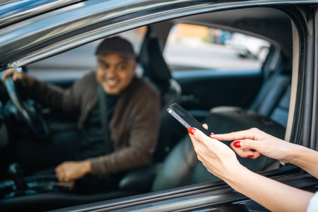 Young asian woman traveler talking with taxi driver explain the route how to travel in direction destination. Passenger showing the direction to taxi driver travel in city. Driver application serviceの写真素材