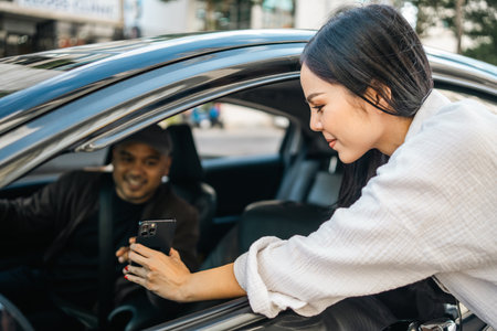 Young asian woman traveler talking with taxi driver explain the route how to travel in direction destination. Passenger showing the direction to taxi driver travel in city. Driver application serviceの写真素材