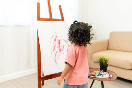 Happy moment little cute girl creating and water color painting activity with paint brushes on frame canvas at living room. Kids activity. Child physical, Emotional, Cognitive development concept.の写真素材