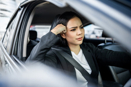 Driving during rush hour But the traffic is very congested. Angry face. Young asian businesswoman has broken down car on the road she feeling serious and stressed. Car crash Look for someone help.の写真素材