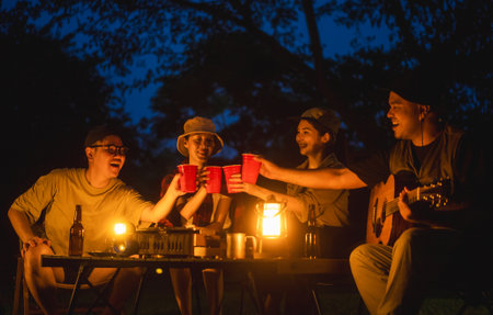Cheers! Group of asian people friend party camping in nature making toasting with soft drink and...