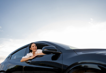 Young beautiful asian business women getting new car. Happy smiling female driving vehicle on the...