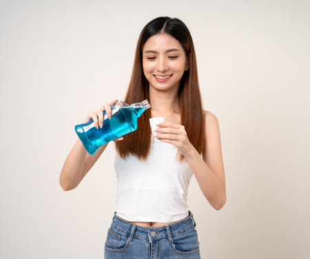 Young asian woman with mouthwash for the health of teeth on isolated. Take care and good dental health fresh breath with mouthwash.の写真素材